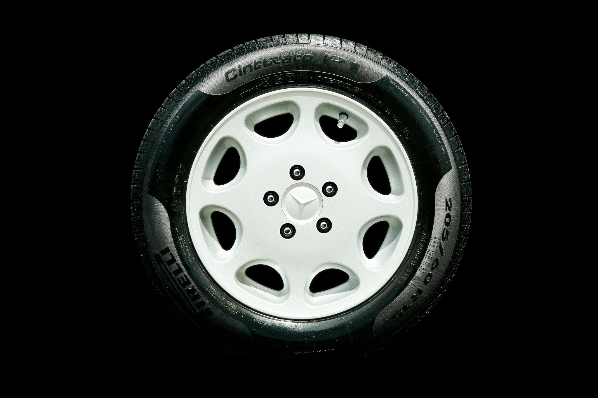 Detailed close-up of a Mercedes alloy wheel with Pirelli tire on a black background.